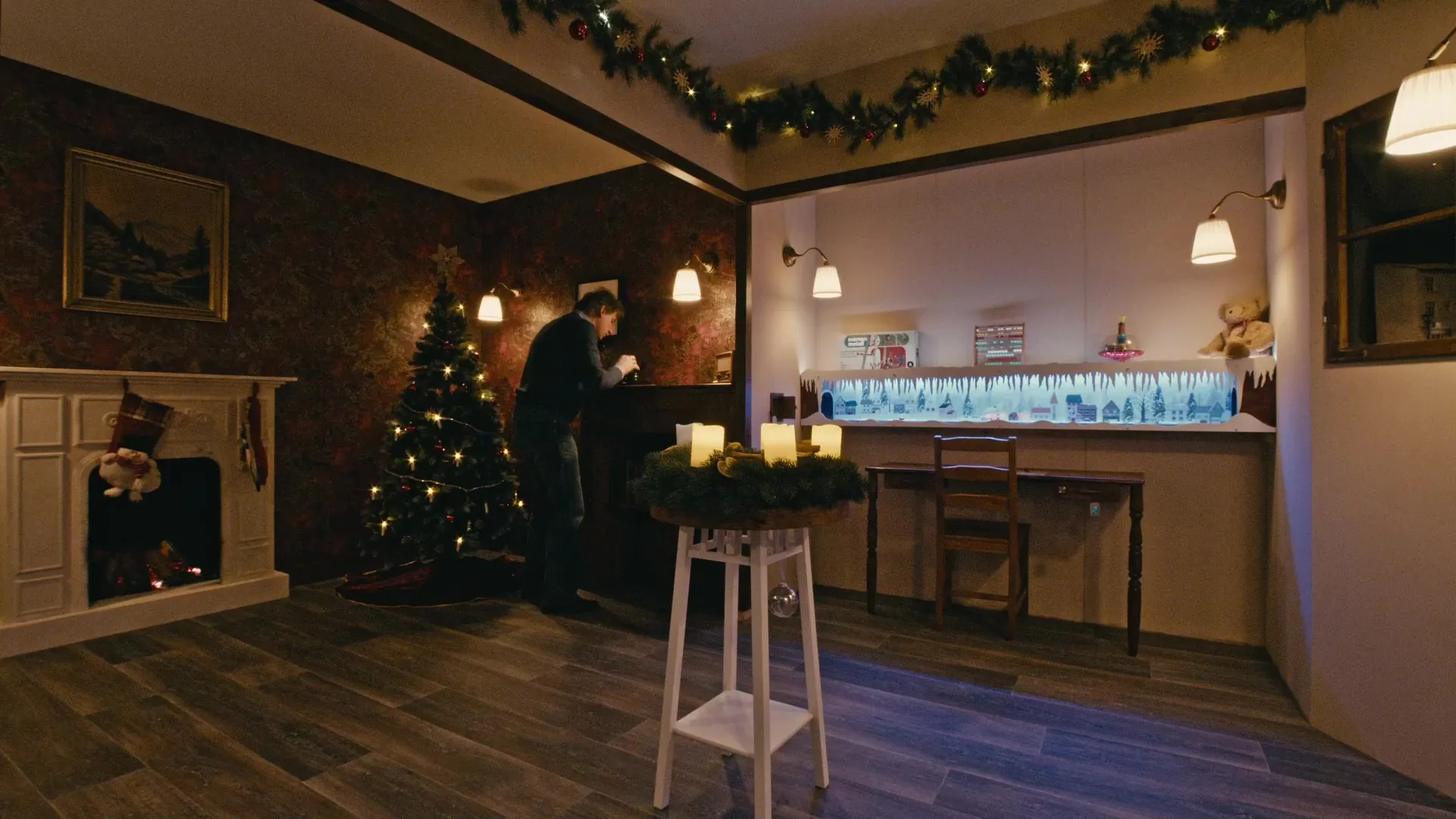 Weihnachtlich dekorierter Escape Room mit Weihnachtsbaum, Kamin und Adventskranz — eine Person sucht nach Rätseln